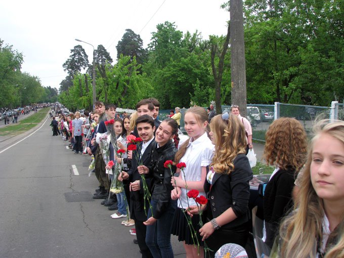 Біля парку Партизанської слави учні Скандинавської гімназії та інших шкіл району створили живий коридор, яким йшли ветерани, вітали їх квітами